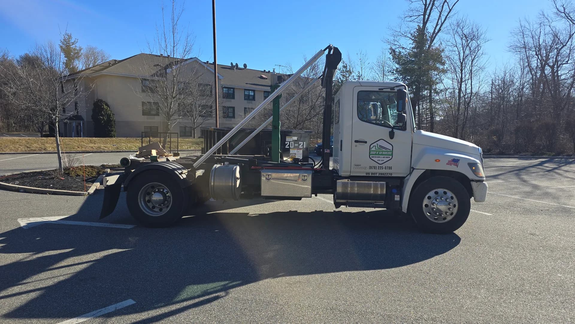 Drop N' Go Haulers roll-off truck carrying a 20 yard dumpster
