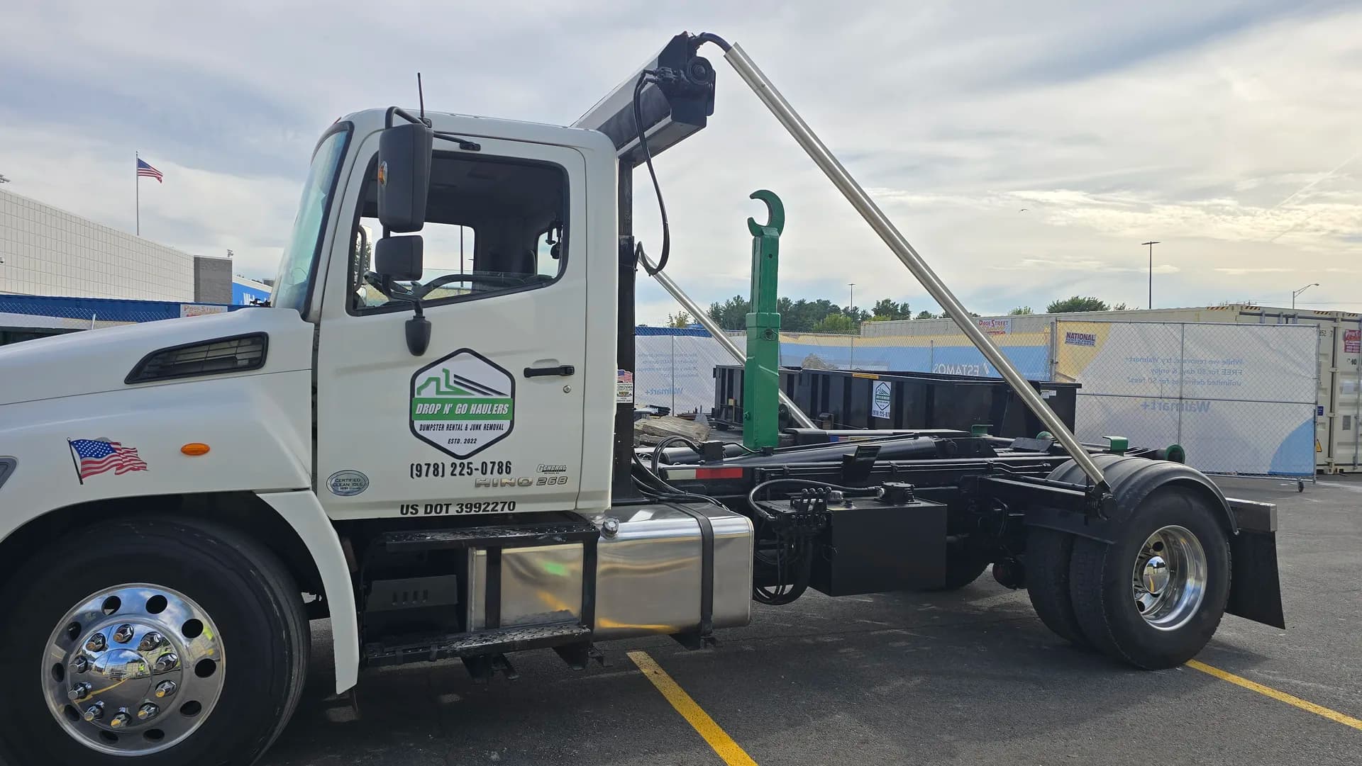 Drop N' Go Haulers branded truck with hook-arm extended